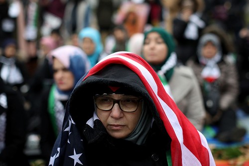 Người biểu tình đội khăn choàng keffiyeh truyền thống của Palestine và khăn mang màu cờ của Palestine.  