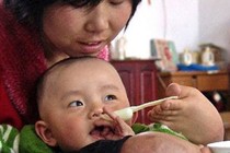 Bà mẹ tật nguyền chăm sóc con nhỏ hoàn toàn bằng chân