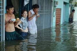 Cảnh nước ngập ngang hông, dân nhai bánh mì... chống chọi