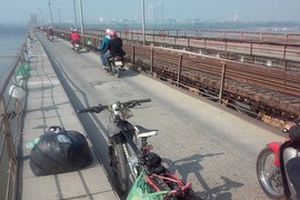 Chàng trai đi xe đạp gom túi nilon trên cầu Long Biên