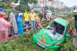 Xe taxi biến dạng tả tơi sau khi bị tàu hỏa kéo lê ở Hà Nội