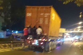 Rợn người cảnh 4 thanh niên đu mình sau container đang chạy