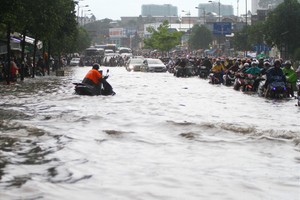 Mưa lớn, đường nội đô TPHCM ngập sâu lút bánh xe, nước chảy như thác cuốn