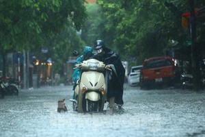 Mưa tầm tã, người dân Hà Nội chật vật ‘bơi qua biển nước’