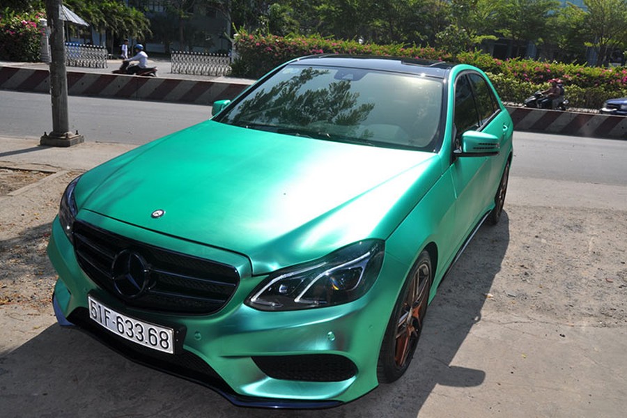 Chiếc  Mercedes E250 AMG được chủ nhân “độ nhẹ” với lớp sơn xe được dán phủ bằng đề-can crôm màu xanh độc đáo biến màu theo từng góc độ nhìn. Nếu chỉ nhìn lướt qua, bạn sẽ khó có thể nhận ra đây là chiếc xe được dán đề can.