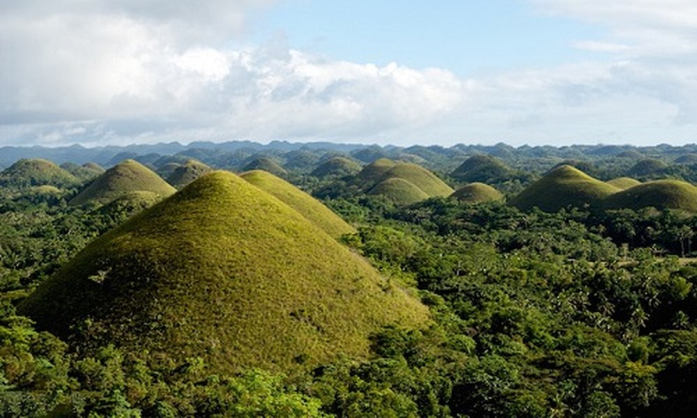 1. Dãy đồi Chocolate  Nằm trên đảo Bohol ở Philippines, những ngọn đồi lớn có hình nón và hình kẹo sô cô la chóp phủ đầy cây cỏ xanh ngắt dường như được hình thành từ bàn tay của một người khổng lồ. Theo truyền thuyết địa phương,  địa danh nổi tiếng này từ giữa những năm 1250 và 1776 và chúng chính là những giọt nước mắt của người khổng lồ. Những gò đất siêu thực này được gọi là Chocolate Hills vì trong mùa khô, cỏ bao phủ biến chúng thành màu sô-cô-la phì nhiêu.