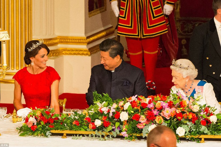 Buổi quốc yến được Nữ hoàng Anh Elizabeth II chủ trì tại Cung điện Buckingham để tiếp đãi Chủ tịch Tập Cận Bình cùng  Đệ nhất phu nhân TQ Bành Lệ Viện trong khuôn khổ chuyến thăm Anh kéo dài bốn ngày của nhà lãnh đạo Trung Quốc. Ảnh: Chủ tịch Trung Quốc Tập Cận Bình tươi cười khi ngồi cùng bàn với Công nương Anh Kate Middleton và Nữ hoàng Elizabeth.