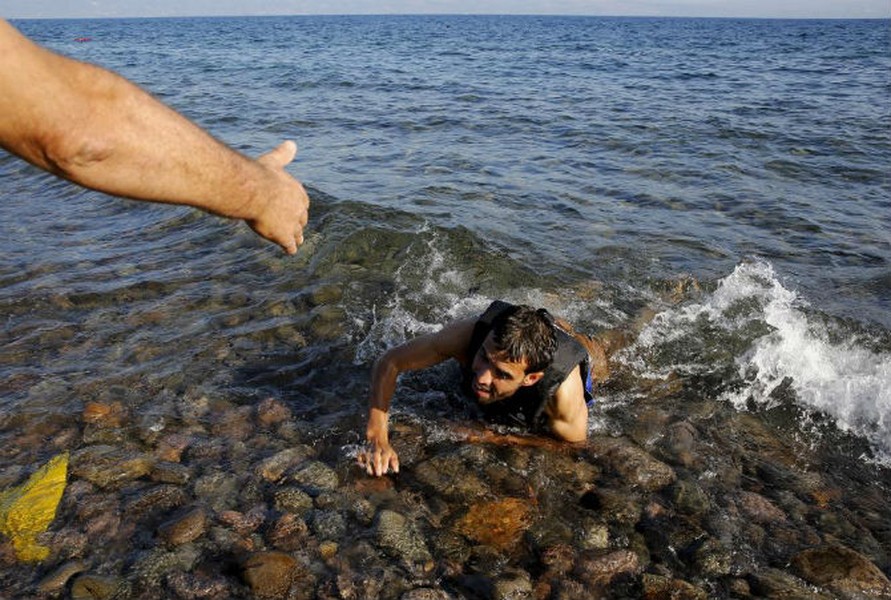 Một  người tị nạn Syria nhảy khỏi một con thuyền đang chìm giữa biển và cố hết sức bơi vào bờ ở đảo Lesbos, Hy Lạp ngày 17/9/2015.