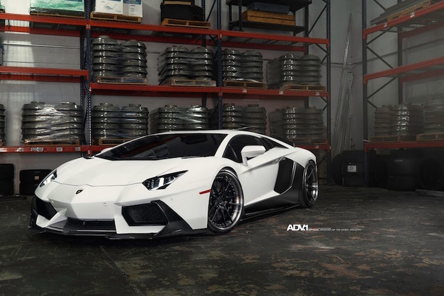 Chiếc  siêu xe Lamborghini Aventador màu trắng đã trở nên ấn tượng hơn so với "đồng loại" khi được trang bị các chi tiết bằng sợi carbon trần tương phản, nằm trong gói độ V-Program của Vorsteiner.