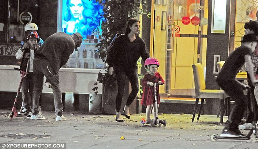 Victoria Beckham cẩn thận đi theo con gái Harper khi cả gia đình đi ăn tối ở Edera, Holland Park, Tây London.