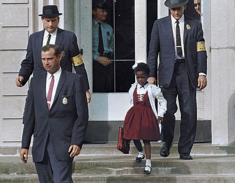 Vào năm 1960, Ruby Bridges trở thành một trong 6 học sinh da đen đầu tiên thi đậu vào trường tiểu học William Frantz vốn dành cho học sinh da trắng ở New Orleans, Mỹ. Tòa án địa phương phải cắt cử 3 cảnh sát người da trắng hộ tống Ruby đến trường.  Bức ảnh lịch sử này gợi nhớ về việc phân biệt chủng tộc diễn ra gay gắt ở Mỹ những năm 1900.