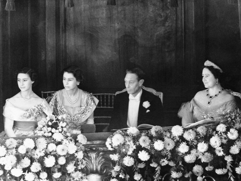 Năm 1950:  Nữ hoàng Anh Elizabeth II là một công chúa trẻ tuổi đang ngồi kế bên ngai vàng của cha mình, vua George VI. Ảnh các thành viên của gia đình hoàng gia Anh từ trái sang phải: Công chúa Margaret, Công chúa Elizabeth, Vua George VI, Nữ hoàng Elizabeth I.