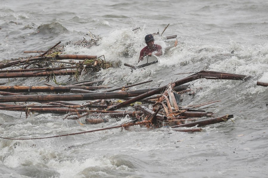  Siêu bão Mangkhut hoành hành hơn 20 giờ trên đảo Luzon, Philippines hôm 15/9. Francis Tolentino, cố vấn của Tổng thống Philippines Rodrigo Duterte, cho biết ít nhất 14 người đã thiệt mạng tới thời điểm hiện tại. Trong ảnh, một người đàn ông liều mạng cứu vớt tài sản trong dòng nước gần thủ đô Manila hôm 15/9. Ảnh: CNN.