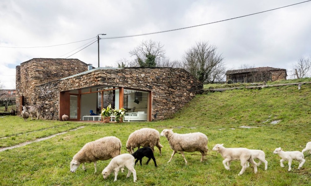 Được đặt tên A'Bodega, ngôi nhà nằm trong vùng rượu vang Ribeira Sacra ở Tây Ban Nha, tòa nhà được xây dựng với những bức tường đá khô truyền thống và có không gian chiều cao gấp đôi ban đầu.  Ngôi nhà đá gồm hai dãy phòng ngủ, trong đó, tầng hầm có chức năng như một không gian sống chia cấp, cũng là phòng ngủ thứ ba và hai sân góc.