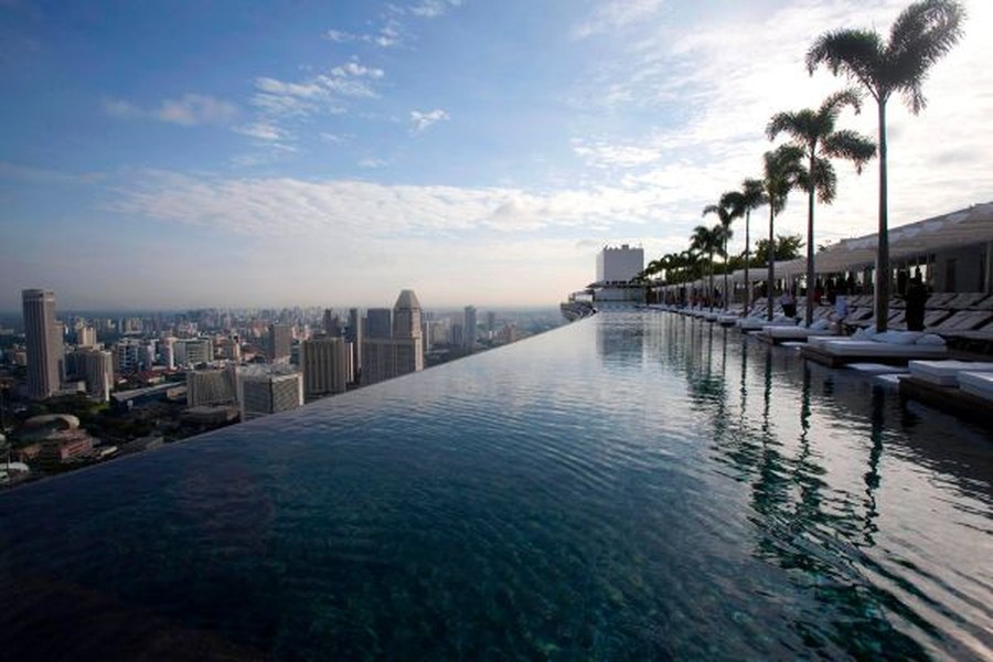 Marina Bay Sands, Singapore Bạn có thể gọi đây là  hồ bơi đẹp tuyệt giữa trời, nơi có độ cao chóng mặt. Đây là hồ bơi trên sân thượng lớn nhất trên thế giới. Nó tọa lạc ở lầu thứ 57 của một tòa cao ốc và thành bể bơi ngay sát mép tòa nhà. Xung quanh bể bơi, họ trồng cả cọ để tỏa bóng mát nên rất mát mẻ. Gió lộng ở hồ bơi giữa trời sẽ mang cho bạn cảm giác khác lạ và không gì so sánh bằng việc ngắm hoàng hôn ở đây.