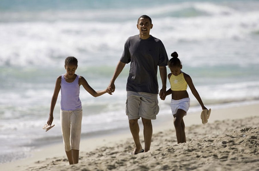 Tổng thống Mỹ Barack Obama nắm tay 2 cô công chúa xinh đẹp đi dạo trên bãi biển trong nghỉ hè ở Martha's Vineyard.