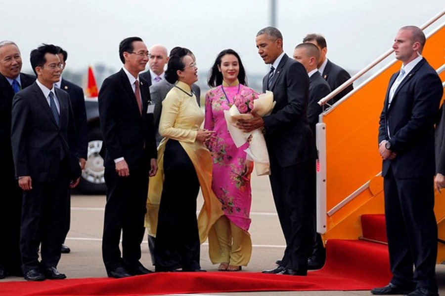 Chiều qua (25/5), chuyên cơ chở Tổng thống Obama đã đáp xuống sân bay Tân Sơn Nhất, TP HCM. Vừa xuống máy bay, vị Tổng thống Mỹ đã nhận được sự đón tiếp nồng nhiệt của các chính khách Việt Nam, thành viên đoàn tiếp đón và người dân Sài Gòn. Cảnh cô gái Sài thành mặc áo dài tặng hoa sen cho ông Obama là một hình ảnh đẹp được phóng viên Reuters ghi lại đã gây ấn tượng mạnh. Ảnh: Reuters.