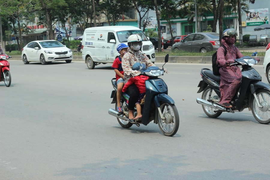 Hình ảnh chụp lại một người  phụ nữ chở theo hai con nhỏ đi trên đường Mễ Trì (Nam Từ Liêm, Hà Nội). Tuy nhiên, những người đi đường thót tim bởi người phụ nữ đặt một con mình ngồi dưới khung xe máy, quay mặt về phía sau ngủ vô cùng nguy hiểm.