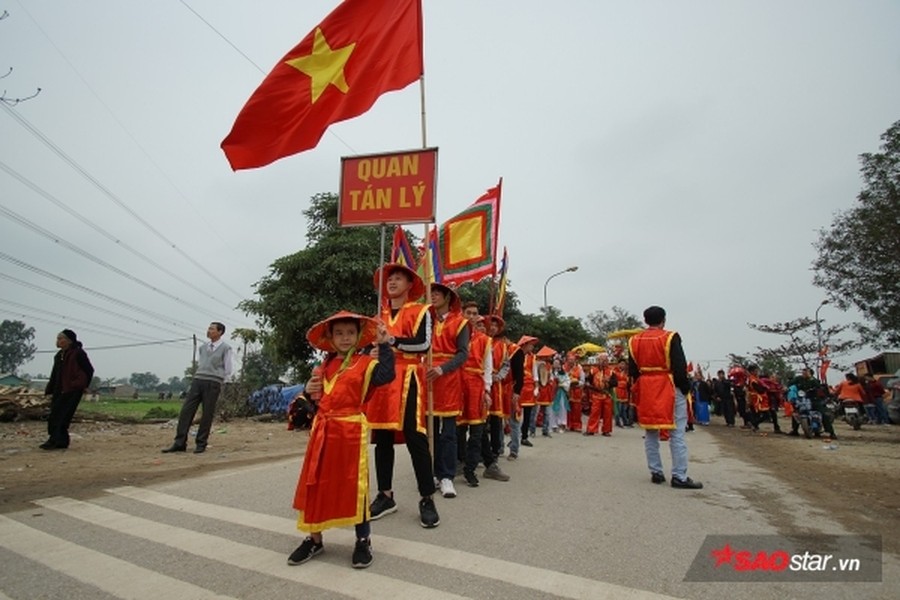 Được biết, mỗi năm người dân trong làng lại chọn ra những người cao tuổi xứng đáng để vào vai “vua, chúa” và 4 vị quan tứ trụ triều đình. Tất cả phải khỏe mạnh; còn đủ song toàn cụ ông, cụ bà; có đức độ và có uy tín trong dân chúng. Trong ảnh, trước khi màn  rước “Vua, chúa sống” là lễ khênh kiệu từ đình làng về đền Sái với màn quay kiệu hừng hực khí thế và vui nhộn. Ảnh: Tường Bách.