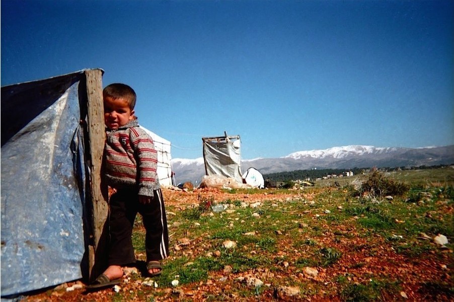 Sau hơn 4 năm xung đột ở Syria, hơn 1,1 triệu người tị nạn đã tìm cách trốn sang Lebanon. Trong ảnh: bé Mohanad đứng cạnh nơi trú ẩn của gia đình ở khu định cư tạm thời tại thị trấn Marjaayoun. Bức ảnh cuộc sống  trẻ em ở trại tị nạn gây xúc động này được chụp bởi bé Omar, 8 tuổi, anh trai của Mohanad.