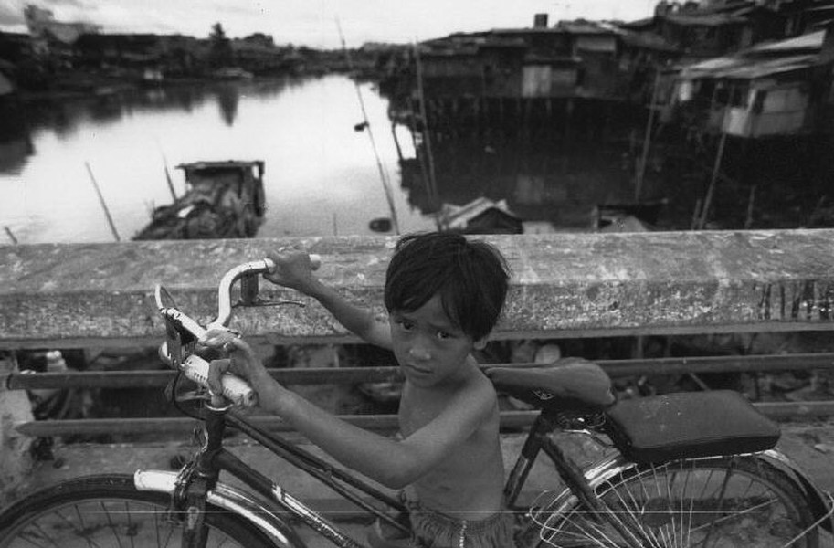 Cậu bé và chiếc xe đạp trên một cây cầu ở TP HCM,  Việt Nam năm 1993. Ảnh: Ferdinando Scianna / Magnumphotos.com.