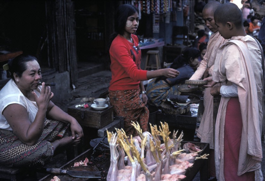 Các quầy thực phẩm trên đường phố thủ đô Rangoon, Myanmar năm 1986. Trên mặt người phụ nữ bán hàng bôi thanaka, loại kem thơm truyền thống làm từ bột vỏ cây có tác dụng trang điểm và chống nắng. Ảnh: Hiroji Kubota/ Magnum Photos.