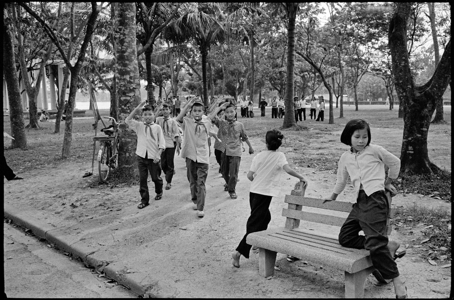 Các đội viên Thiếu niên Tiền phong diễu hành trong công viên Thống Nhất ở Hà Nội,  Việt Năm năm 1975. Ảnh: A. Abbas/ Magnum Photos.