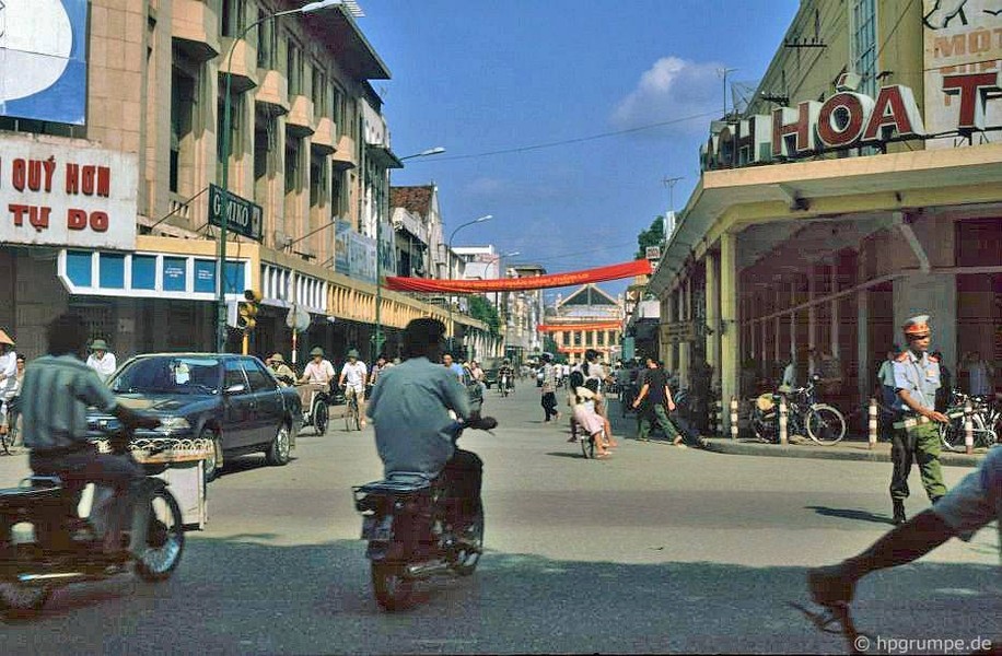 Các nam giới đi  xe máy Honda Cub chạy qua ngã tư Tràng Tiền - Đinh Tiên Hoàng, Hà Nội năm 1991. Ảnh: Hans-Peter Grumpe / Hpgrumpe.de.