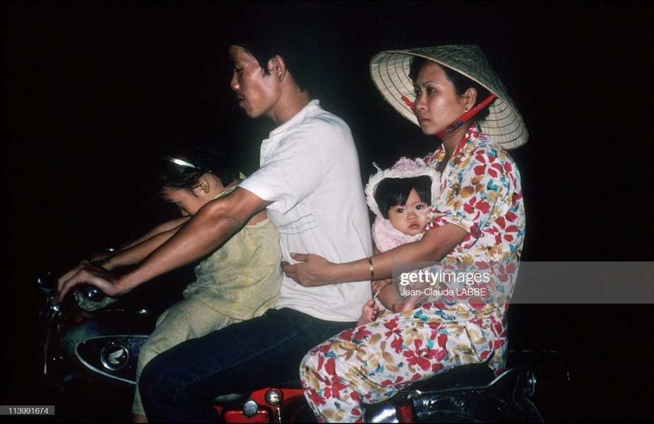 Một gia đình vi vu trên xe máy vào buổi tối ngày thứ Bảy,  TP. HCM năm 1991. Ảnh: Jean-Claude Labbe/ Getty Images.