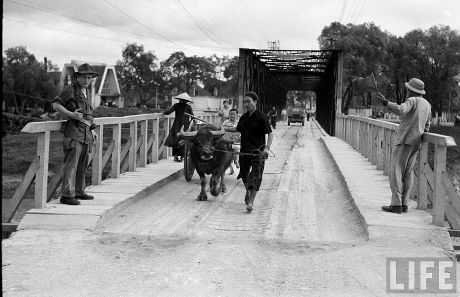 Người dân qua lại trên cầu Kỳ Lừa,  thị xã Lạng Sơn năm 1950. Ảnh: Carl Midans / Life.