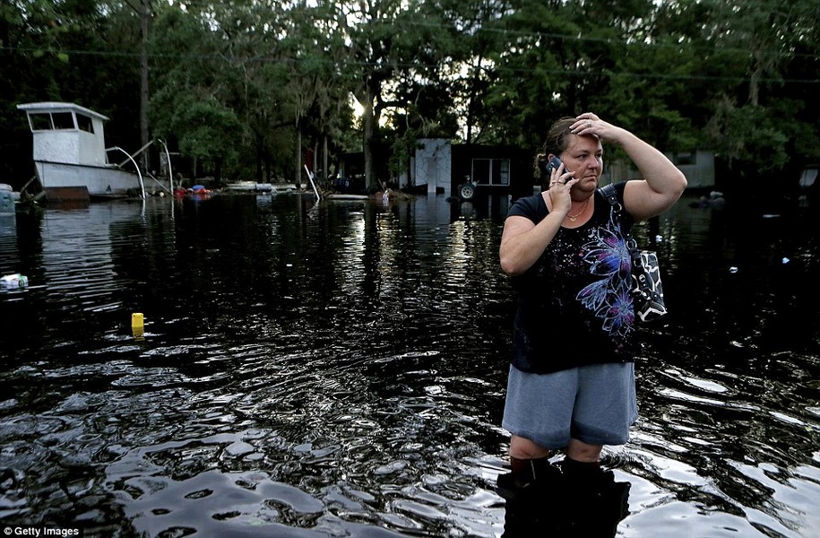 Sáng 2/9,  cơn bão Hermine đã đổ bộ vào khu vực bờ biển ở vịnh phía bắc bang Florida mang theo sức gió lên tới 130 km/h. Ảnh: Chị Lynne Garrett gọi điện thoại cho người thân khi chị về lại nhà mình sau khi cơn bão nhiệt đới Hermine đổ bộ, gây mưa lớn ở Tampa, bang Florida đêm hôm trước 1/9.