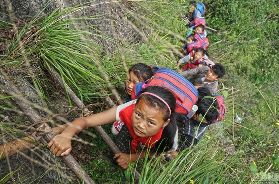 Các em  học sinh Trung Quốc ở độ tuổi còn khá nhỏ đang cẩn thận leo lên một bậc thang để trở về nhà sau thời gian học ở trường. Chúng leo theo dây thang nguy hiểm này mà không có bất cứ đồ bảo hộ nào.