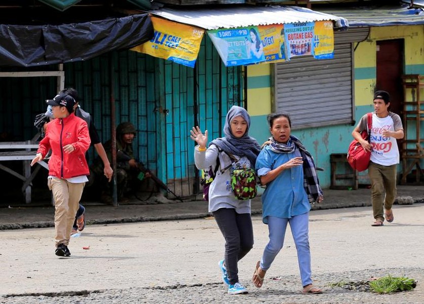 Những người dân chạy sơ tán trong lúc các binh sỹ chính phủ tấn công vào  nhóm khủng bố nam Philippines là Maute sau khi chúng chiếm giữ thành phố Marawi trên đảo Mindanao.