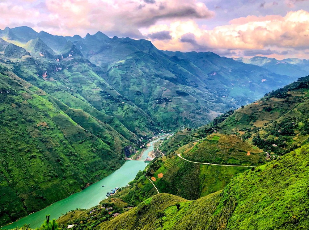 Bên bờ sông Lô và những dãy núi mù sương bao quanh,  Hà Giang được miêu tả là "nơi thời gian như ngừng trôi". Các cung đường đèo hiểm trở ở Hà Giang hấp dẫn những tín đồ mê cảm giác mạnh. Tỉnh miền núi phía Bắc này là nơi sinh sống của nhiều dân tộc thiểu số. Du khách có thể khám phá các di sản văn hóa ở thị trấn Đồng Văn hay hòa mình vào những phiên chợ vùng cao đầy náo nhiệt. Ảnh: Lê Vinh Đệ.