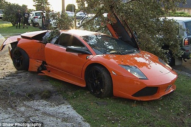 Khi đang khoe sức mạnh”  "siêu bò"  Lamborghini Murcielago cho khách đến mua xe xem - chủ nhân siêu xe màu cam tại Sydney, Úc đã mất lái và lao sang bên đường đâm bật gốc 1 cái cây.