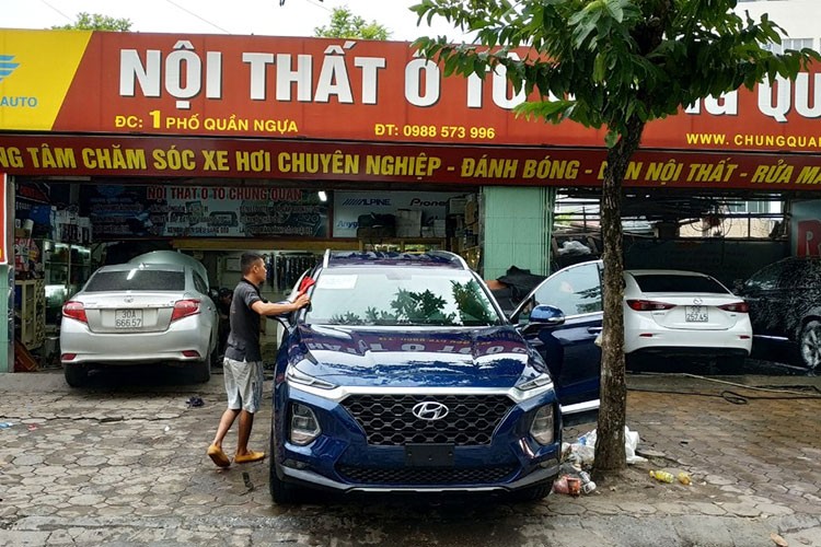 So với mẫu xe đang trưng bày tại toà nhà Thành Công, chiếc  Hyundai SantaFe 2019 tại Hà Nội này có vẻ như đầy đủ option hơn. Bên ngoài có thể quan sát thấy hệ thống camera 360 độ với chiếc Camera được đặt dưới logo phía trước. Ngoài ra chiếc xe này còn có hệ thống dẫn động 2 cầu với ký hiệu HTRAC ở phía sau đuôi xe. Trong khi mẫu xe trưng bày tại toà nhà Thành Công trước đó là phiên bản 1 cầu 2.0D.