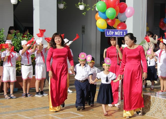 Tại trường tiểu học Lê Văn Việt, quận 9, TP.HCM, các cô giáo đang nắm tay những "cô, chú heo vàng" tiến vào sân trường.