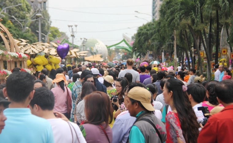 Dù giữa trưa nắng nhưng vẫn có hàng chục ngàn người đổ về đường hoa Nguyễn Huệ để thăm quan.