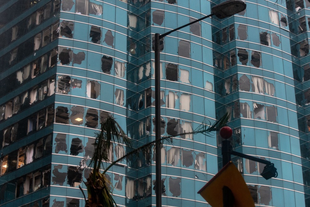 Hong Kong gần như tê liệt vào ngày 16/9 khi siêu  bão Mangkhut đổ bộ. Cửa kính nhiều nhà cao tầng vỡ vụn trước sức gió có lúc đạt đến 195 km/h. Đây là cơn bão có sức gió kinh hoàng nhất từng đổ bộ vào Hong Kong kể từ bão Hy vọng năm 1979. Trong ảnh, cảnh tượng tan hoang của tòa cao ốc One Harbourfront chiều 16/9 sau khi cơn bão đi qua. Ảnh: AFP.