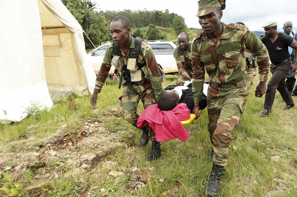 Chính phủ Zimbabwe cho biết bão Idai đã làm hơn 100 người thiệt mạng ở Chipinge và Chimanimani. Người dân cho rằng con số có thể cao hơn vì những khu vực bị ảnh hưởng nặng nề nhất vẫn không thể tiếp cận được. Trong ảnh, các binh sĩ mang theo những người sống sót bị thương từ một máy bay trực thăng ở Chimanimani, cách thủ đô Harare, Zimbabwe khoảng 600 km về phía đông nam, ngày 19/3. Ảnh: AP.