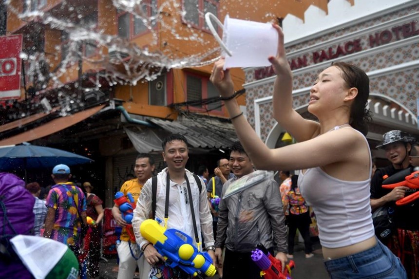 Một du khách Trung Quốc trong  lễ hội Songkran trên đường Khaosan ở Bangkok. Lễ hội năm mới - được gọi là Songkran ở Thái Lan, Chol Chnam Thmay ở Campuchia, Bunpimay ở Lào và Thingyan ở Myanmar - diễn ra vào tháng 4 hàng năm. Truyền thống té nước là để rửa sạch xui xẻo và cầu nguyện cho một năm mới tốt lành.