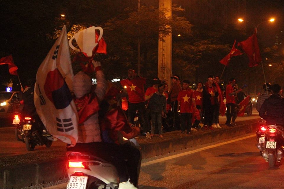 Sau chiến thắng mỹ mãn của đội tuyển Việt Nam trong trận chung kết AFF Cup 2018, hàng nghìn người hâm mộ đổ ra đường ăn mừng cùng cờ, áo đỏ rực, trống kèn... khuấy động nóng bầu không khí giữa đêm đông.