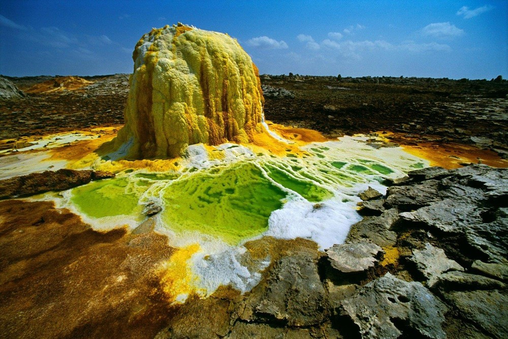 Khu vực quanh núi lửa Dallol ở Ethiopia là một nơi cực kỳ lạ lùng, không giống bất cứ đâu trên trái đất. Hơi độc clo kèm lưu huỳnh làm tắc nghẽn không khí. Trong khi đó, những đụn muối và sắt có hình hài như nấm khổng lồ bao phủ toàn bộ cảnh quan. Ảnh: Red Bull.