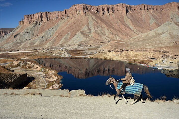 Một nam giới Afghanistan cưỡi ngựa đi qua hồ nước Band-e-Amir nằm trong vườn quốc gia của nước này ở tỉnh Bamiyan vào tháng 11/2016. Bamiyan nằm trên Con đường Tơ lụa xưa.Ảnh: Reuters.