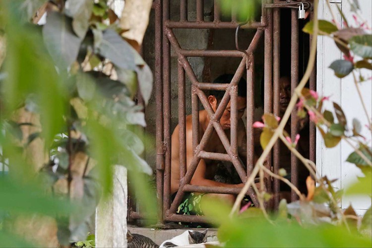 Công nhân người Thái Lan và Myanmar bị nhốt như nô lệ sau những "chấn song sắt"công ty sản xuất thủy sản của Thái Lan đặt tại Benjina, Indonesia. (ảnh: AP). Loạt ảnh về " nô lệ ở xưởng chế biến thủy sản" đã giúp AP đoạt giải Pulitzer.