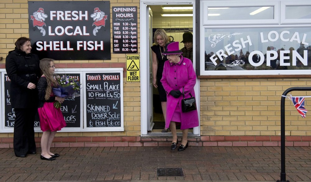  Nữ hoàng Anh Elizabeth II bước ra khỏi một cửa hàng bán cá ở Newhaven, Sussex. Ảnh: BI.