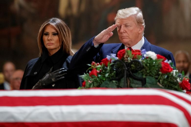 Tổng thống Trump, đứng cạnh Đệ nhất phu nhân Mỹ Melania, chào trước linh cữu cố Tổng thống  Bush cha trong Điện Capitol ngày 3/12. (Nguồn ảnh: Reuters)