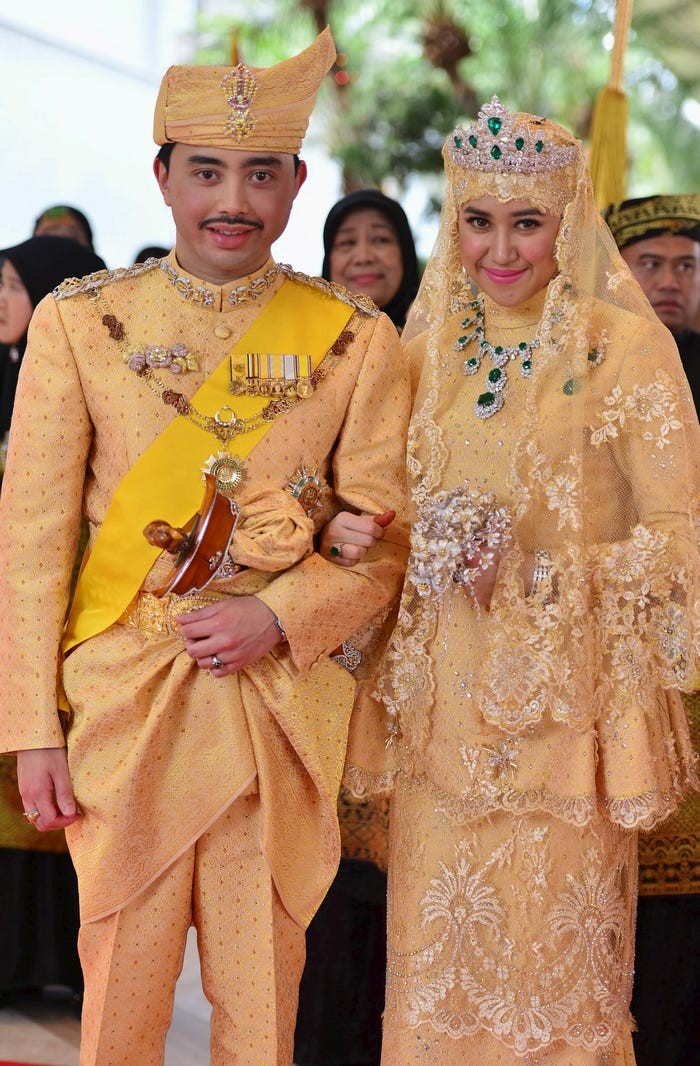 Theo Insider, Hoàng tử Brunei Abdul Malik kết hôn với Dayangku Raabi'atul 'Adawiyyah Pengiran Haji Bolkiah tại Cung điện Istana Nurul Iman vào năm 2015. Trong đám cưới, cô dâu mặc bộ váy dát vàng, đính đá quý lấp lánh. Ngoài ra , cô dâu Hoàng gia Brunei này còn cầm theo một bó hoa làm bằng đá quý, đội vương miện kim cương. (Nguồn ảnh: Insider)