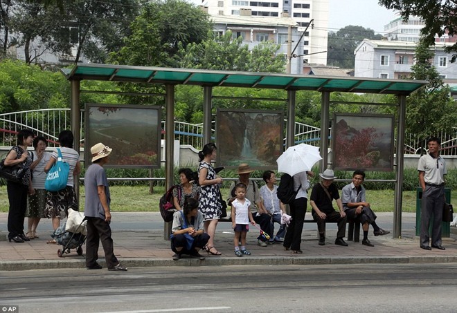 Người dân gồm người già và trẻ nhỏ chờ xe buýt tại một điểm đỗ ở  thủ đô Triều Tiên. Ảnh: AP.