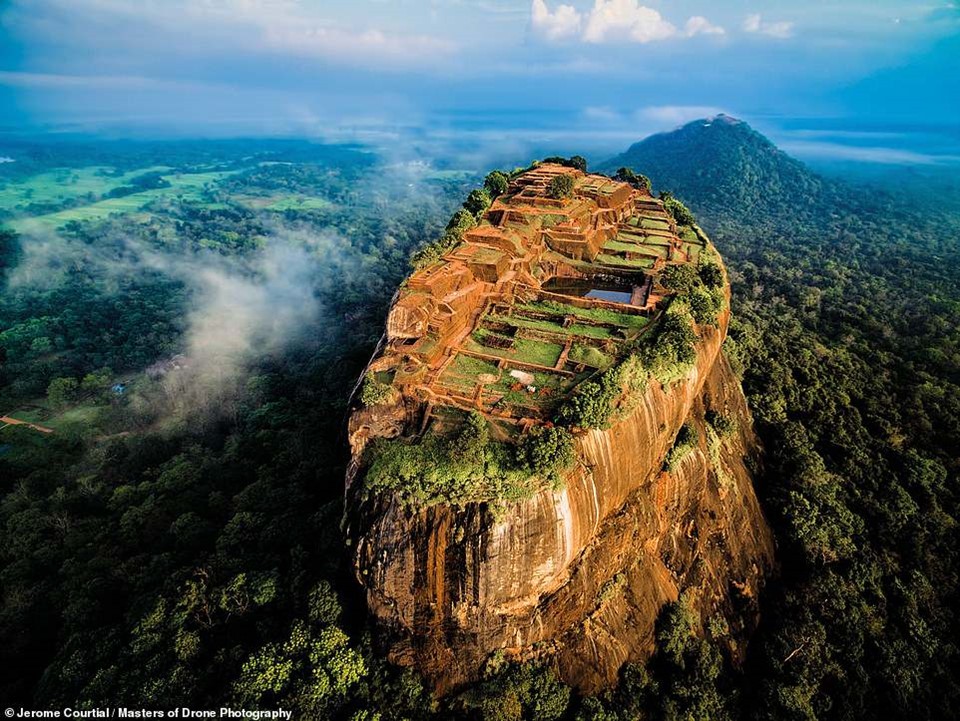 Sigiriya ở Sri Lanka là phế tích cung điện cổ được xây trên núi đá cao 370 m dưới triều đại vua Kassapa I (477-495). Jerome Courtial, tác giả của  bức ảnh, cho biết anh gặp khó khăn khi tìm chỗ bay fly cam. Bao quanh Sigiriya là khu rừng rậm với nhiều loài động vật hoang dã sinh sống. "Tôi khá may mắn khi có thể bắt ánh sáng đẹp. Những đám mây nhỏ bên trái khiến cho bức hình trở nên dễ chịu hơn", anh nói.